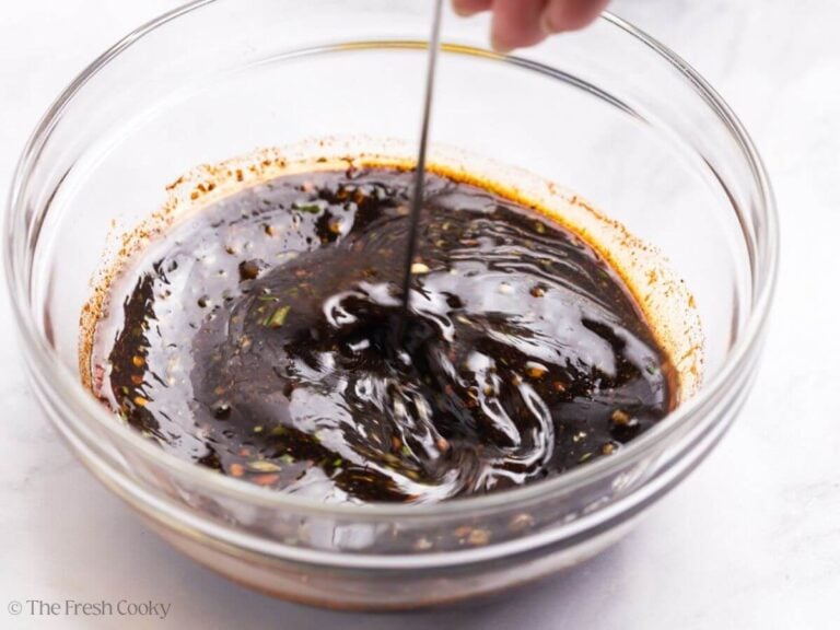 Using a small whisk to mix the pork chop marinade together.