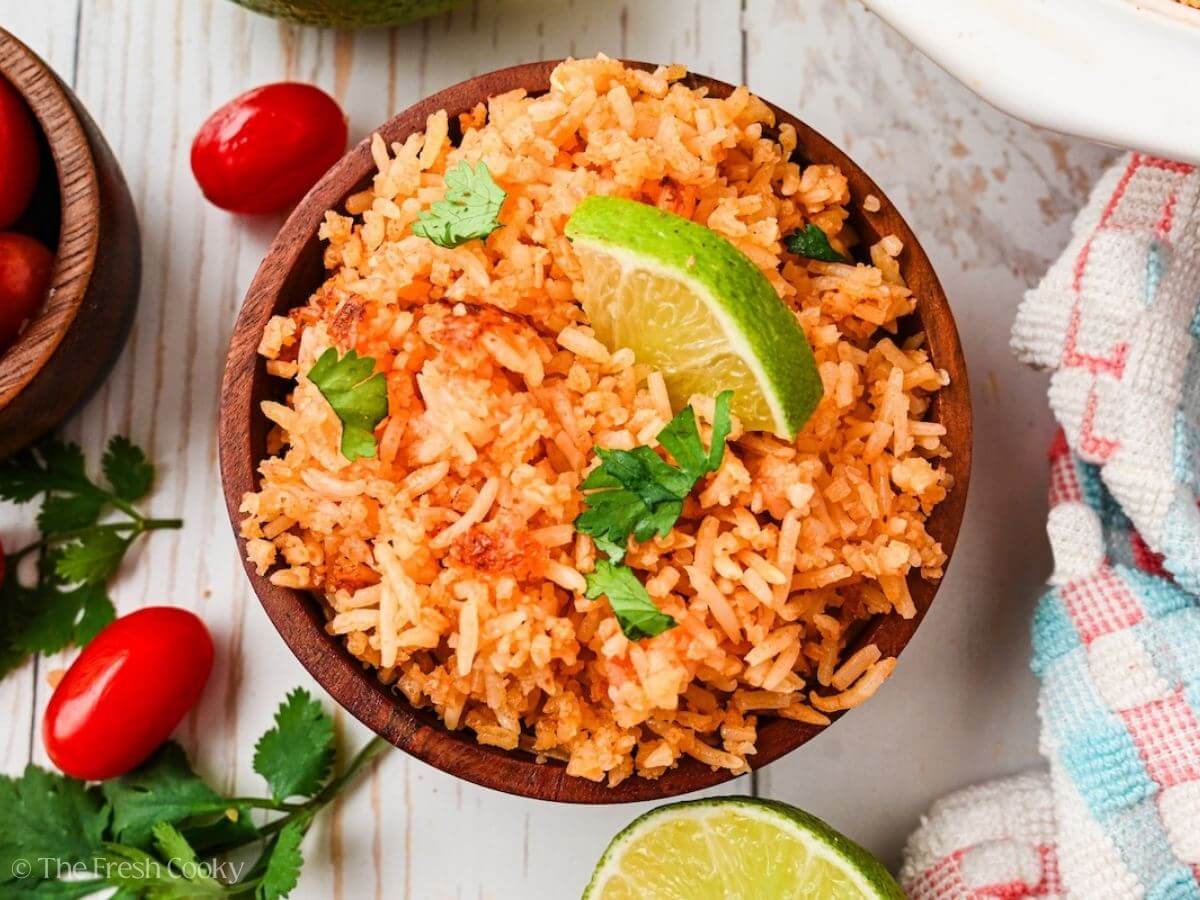 Overhead shot of Spanish rice in a small bowl with lime and cilantro on top.