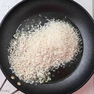 Rice in a skillet with oil.
