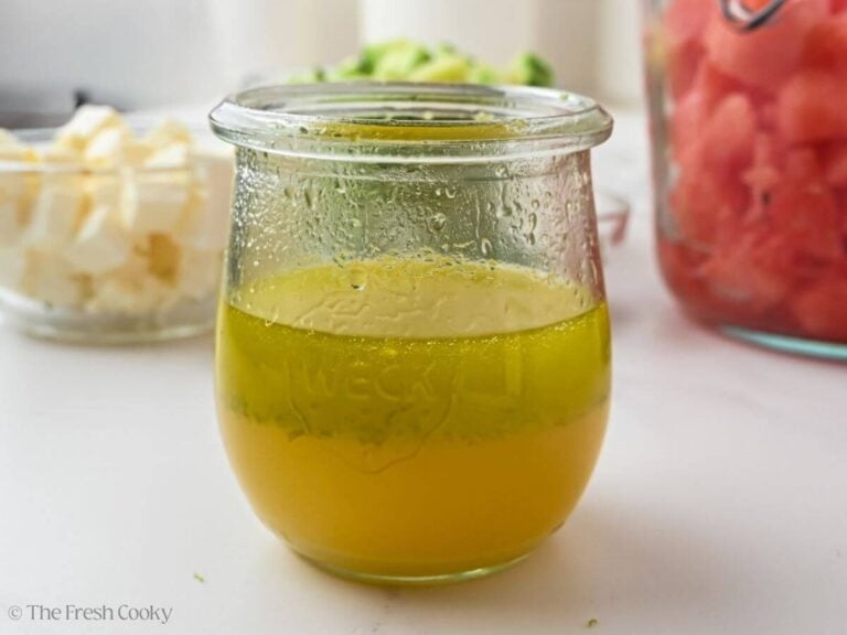 Side view of the dressing ingredients in a small glass jar.