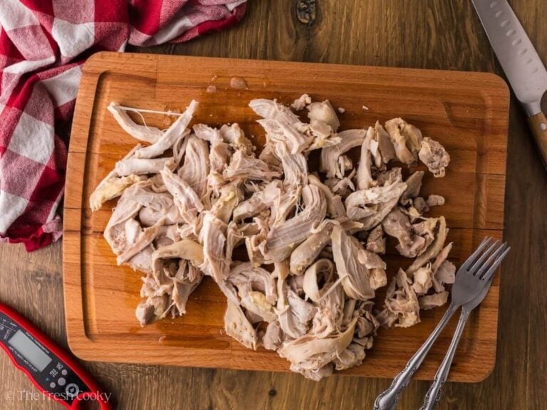 Shredded chicken on a wooden cutting board.