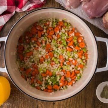 Onion, celery and carrots sauteing in a pot.