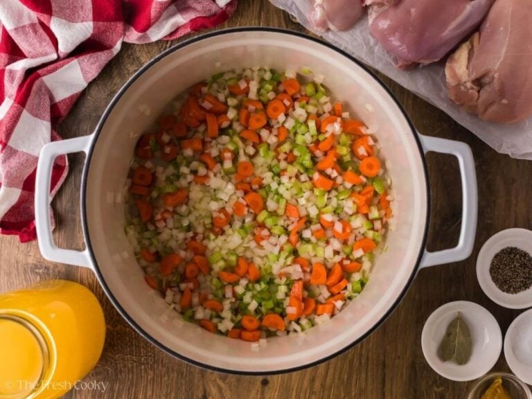 Onion, celery and carrots sauteing in a pot.