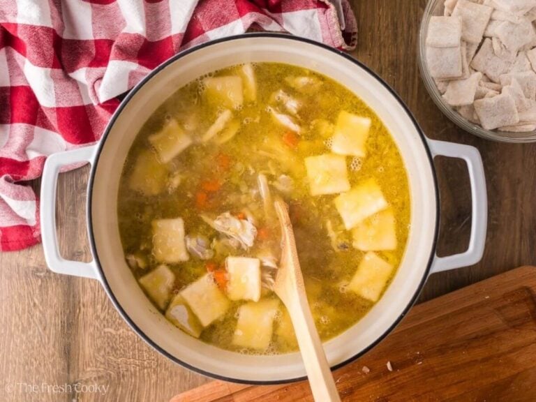 Chicken and dumplings cooking in a large pot.