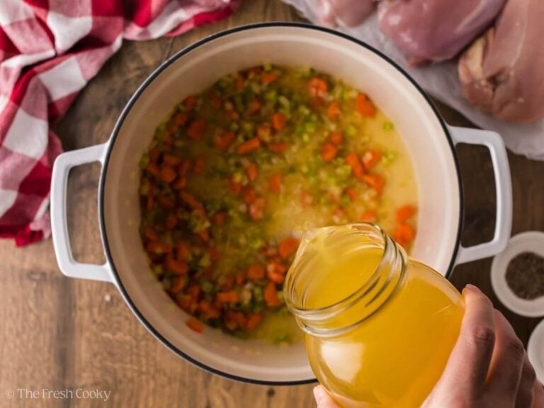 Chicken broth being added to the large soup pot.