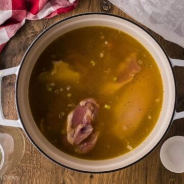 Chicken added to the pot of broth and vegetables.