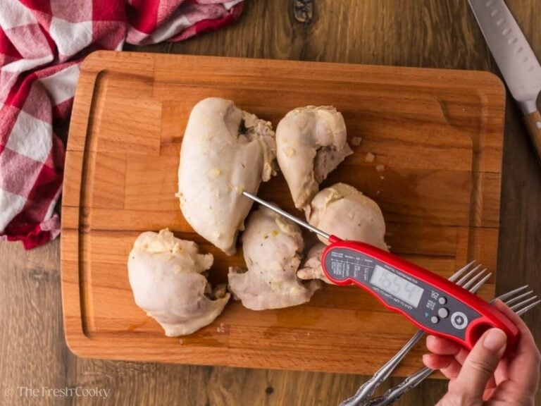 Using a meat thermometer to check the internal temp of the chicken.