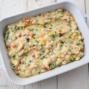 Chicken por pie filling placed in a white baking dish.