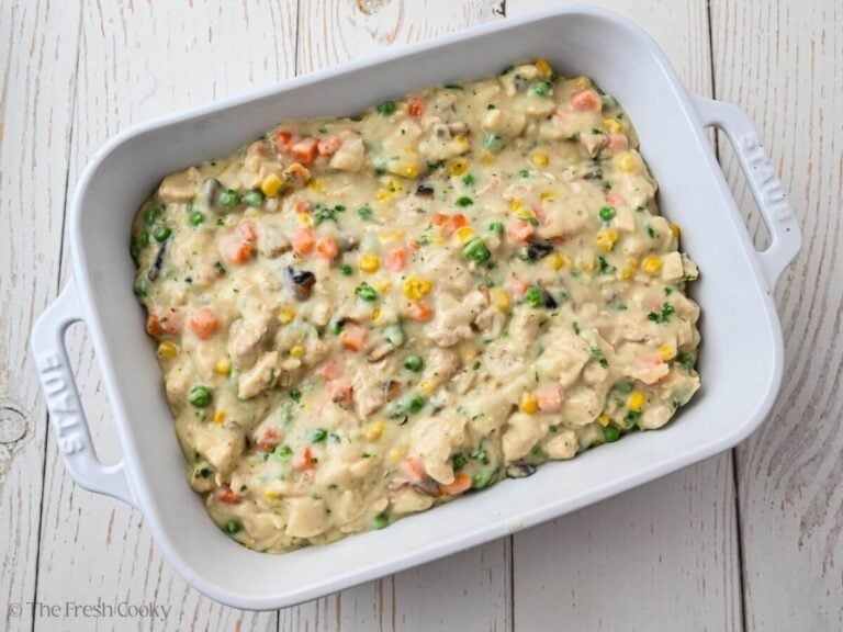 Chicken por pie filling placed in a white baking dish.