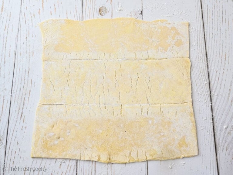Sheet of puff pastry folded out onto a floured surface.