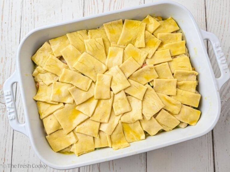 Puff pastry squares brushed with egg wash before baking.
