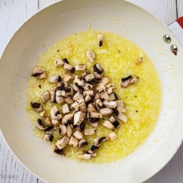 Mushrooms, onions and olive oil in a skillet.