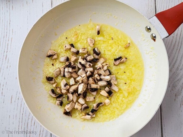 Mushrooms, onions and olive oil in a skillet.