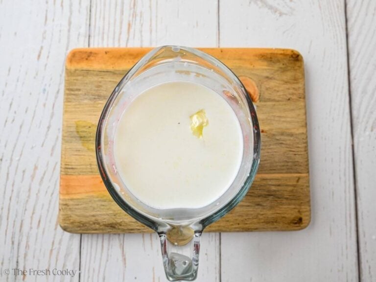 Garlic added to half and half in a measuring cup.