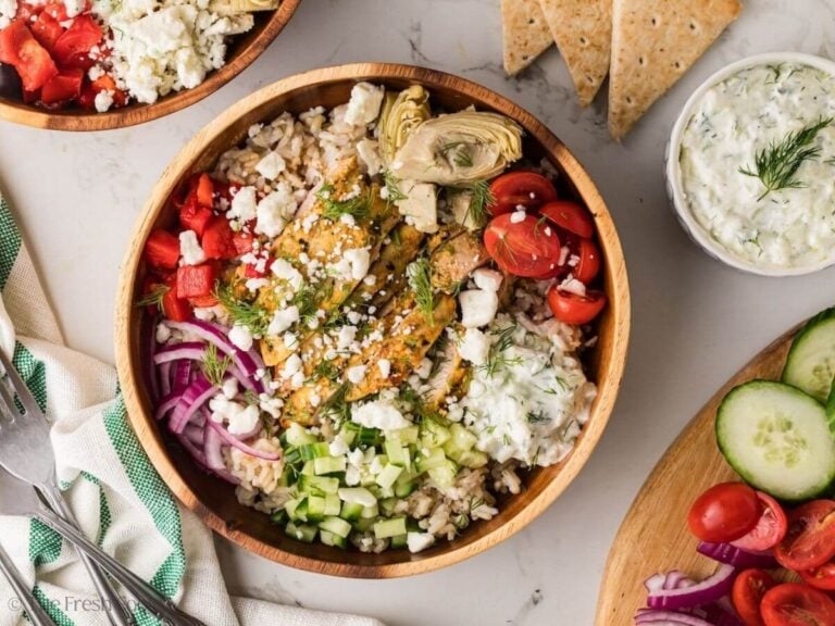 Overhead shot of a Greek chicken bowl sered in a wooden bowl.