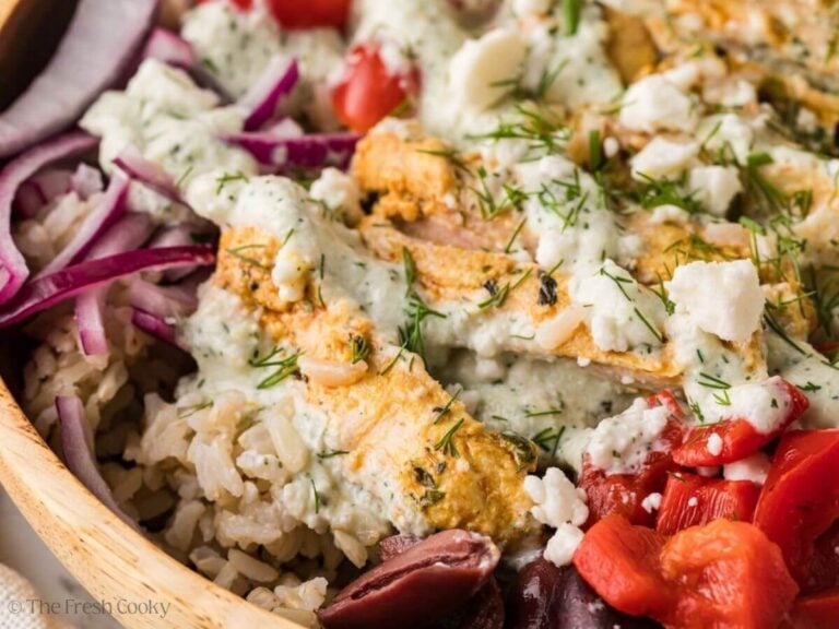 Side view of sliced chicken on a bed of rice with sauce on top.
