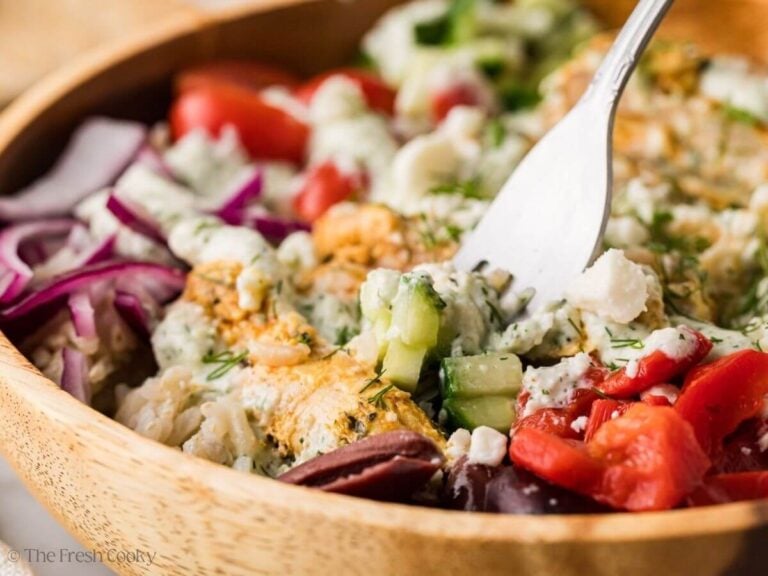 Fork picking up a bite from a Greek chicken bowl.