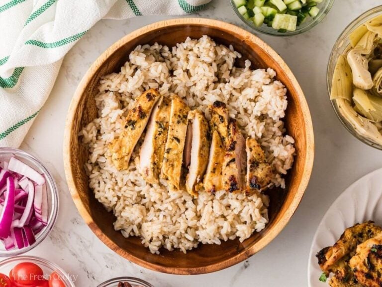 Rice in a bowl with sliced Greek chicken on top.