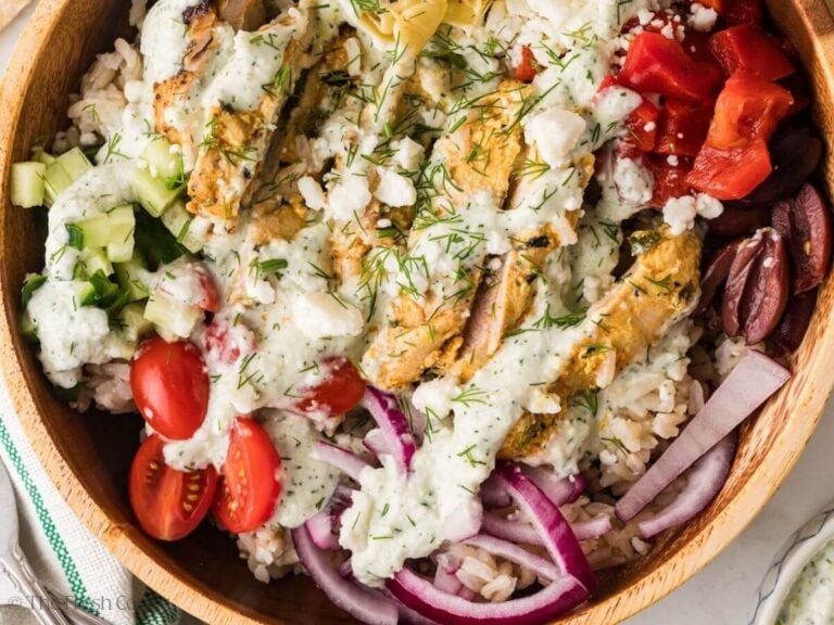 Finished Greek chicken bowl assembled with sauce on top.