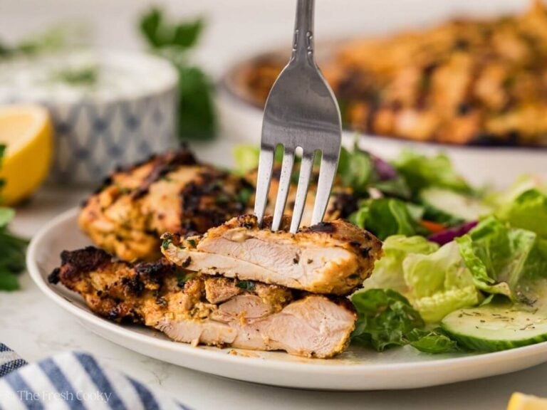 Fork grabbing a bite of juicy grilled, marinated Greek yogurt chicken thighs.