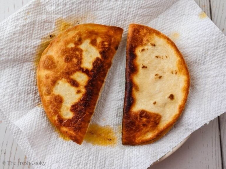 Two ground beef tacos on paper towels after being fried.