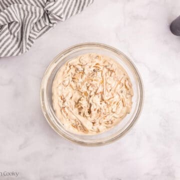 Onions folded into the cream of mushroom mixture in a bowl.