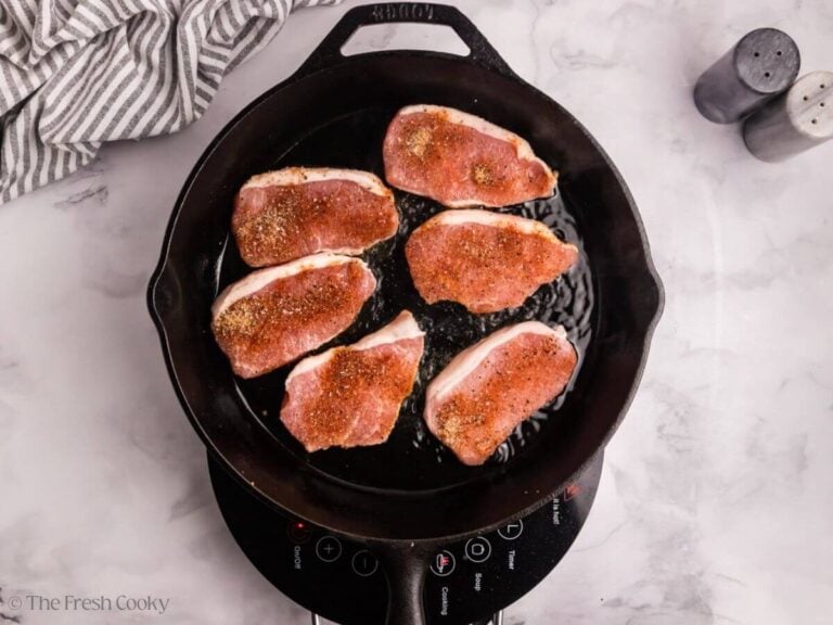 Pork chops in a skillet to sear.