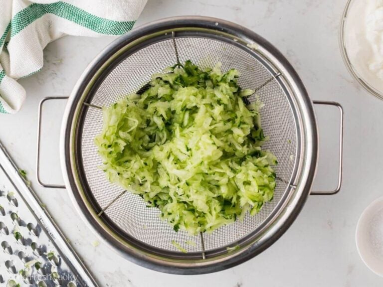Grated cucumber in a fine mesh sieve.
