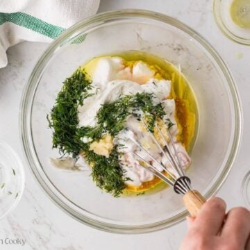 Whisking together the tzatziki ingredients in a bowl.