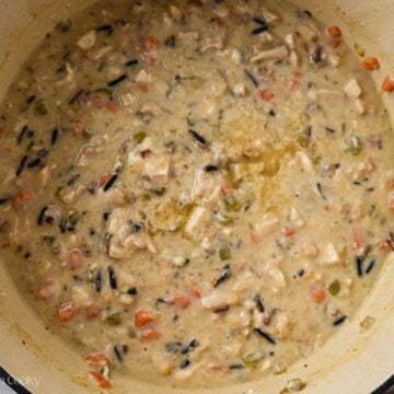Roux stirred into the wild rice soup in a pot.
