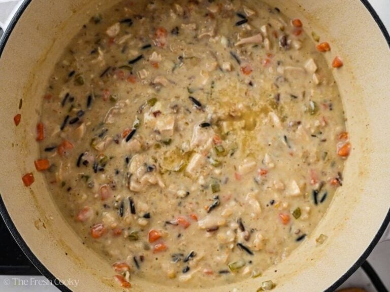 Roux stirred into the wild rice soup in a pot.
