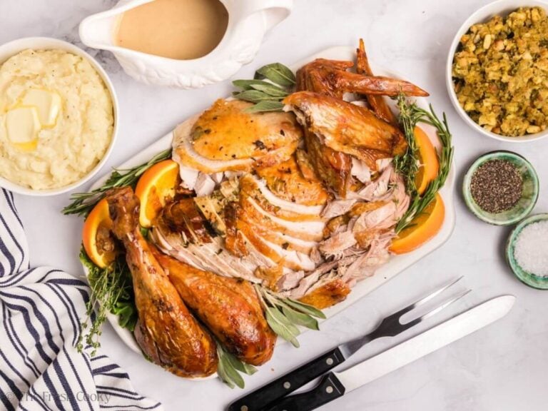 Carved herb butter turkey on a serving platter.