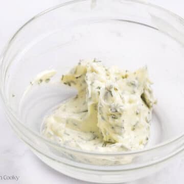 Butter mixed together with herbs in a bowl.