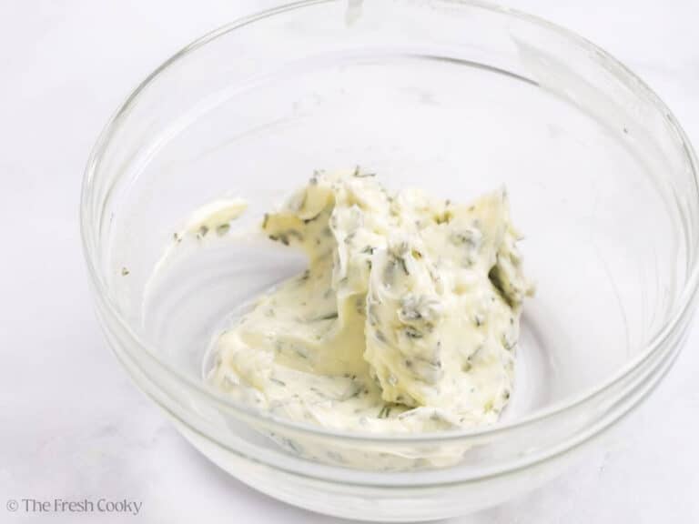 Butter mixed together with herbs in a bowl.