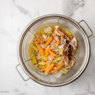 Straining the chicken stock from the veggies and chicken.