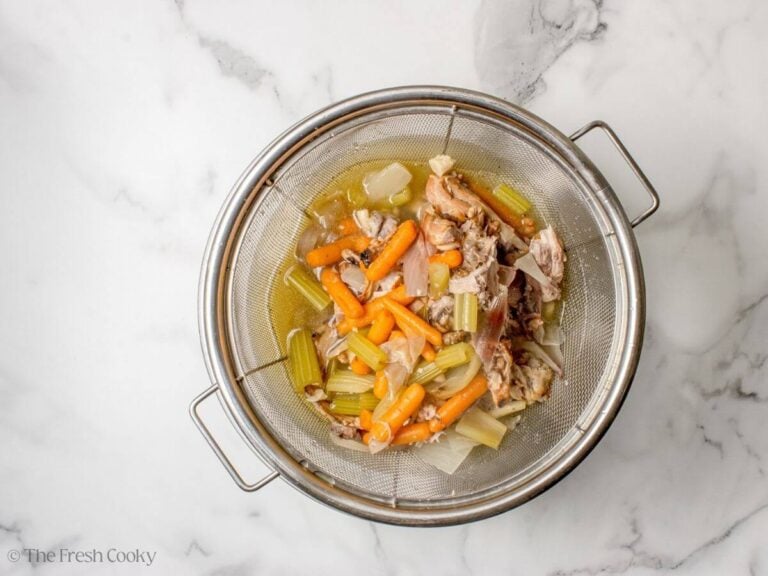 Straining the chicken stock from the veggies and chicken.