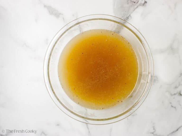 Strained chicken broth in a large bowl.
