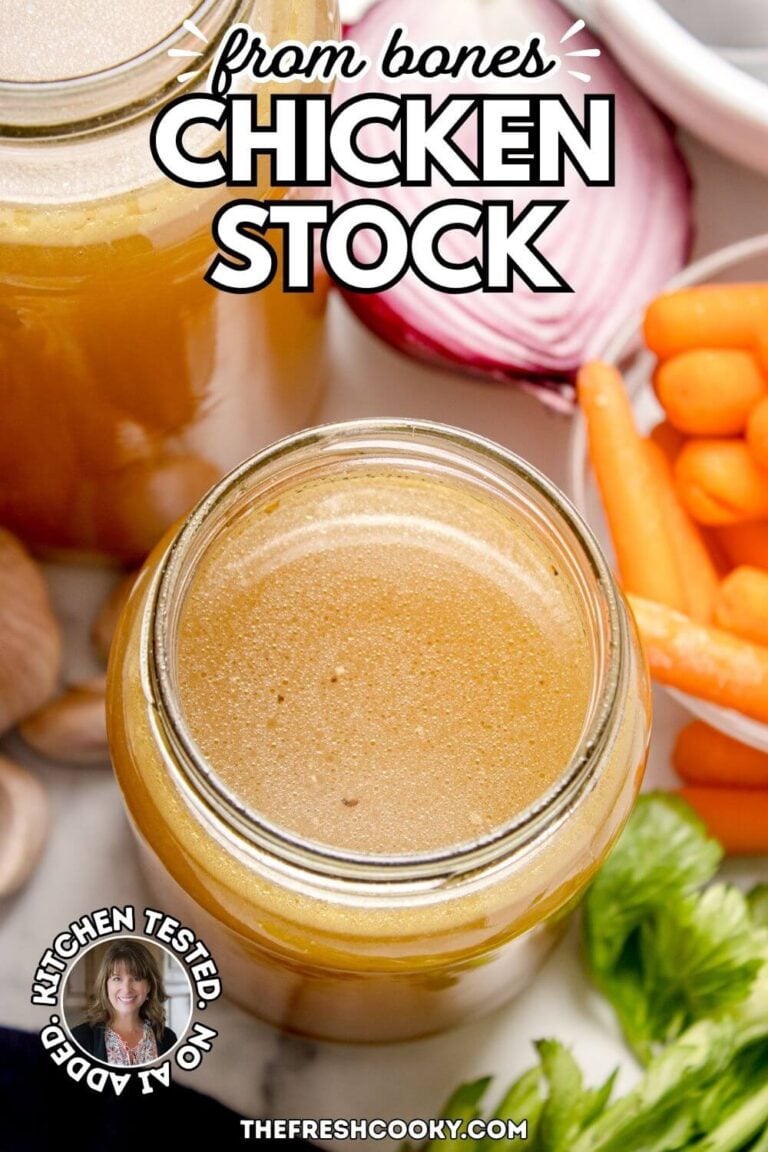 A few glass jars filled with rich, golden chicken broth, surrounded by carrots, celery, onions, and garlic, for pinning.