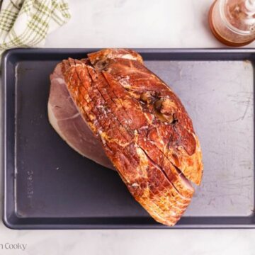 Spiral sliced ham on a baking sheet, prepping for cooking.