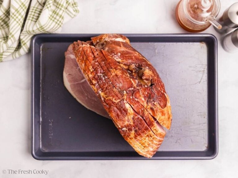 Spiral sliced ham on a baking sheet, prepping for cooking.