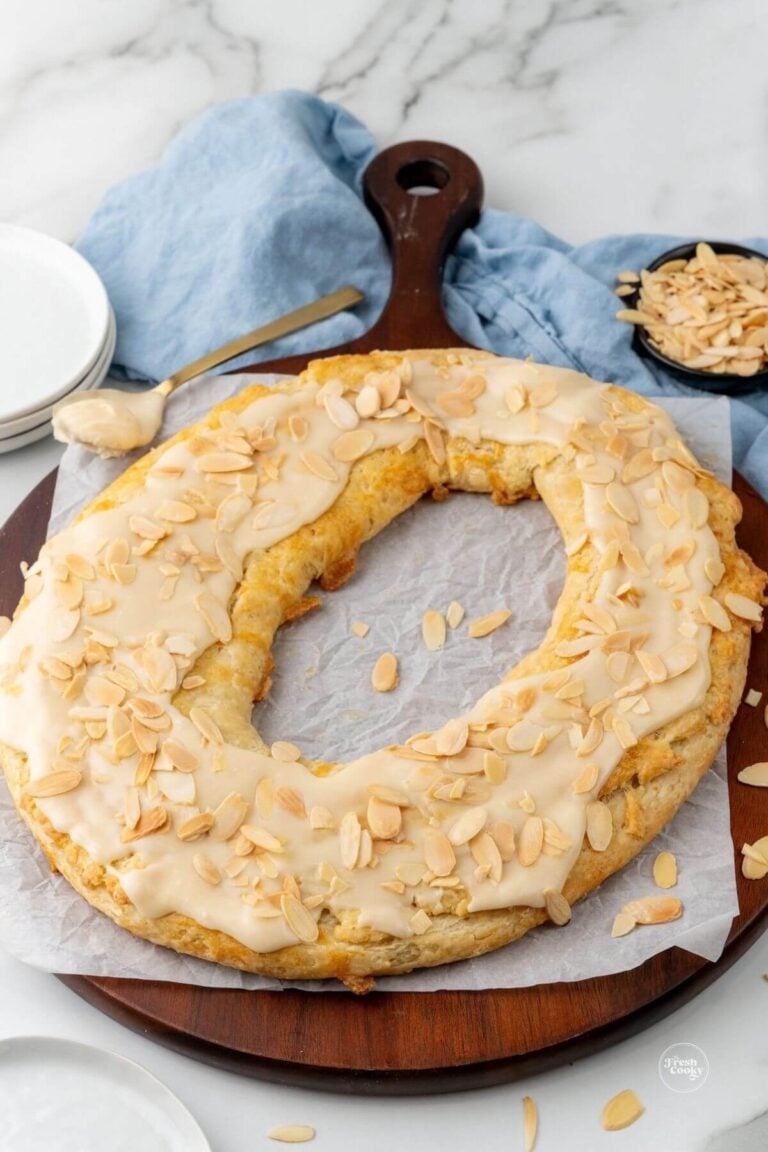 Overhead shot of a round almond kringle served on a wooden board.