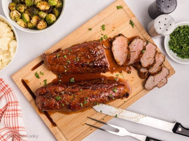 Overhead shot of a plate with sliced maple Dijon pork tenderloin, mashed potatoes, and Brussels sprouts.