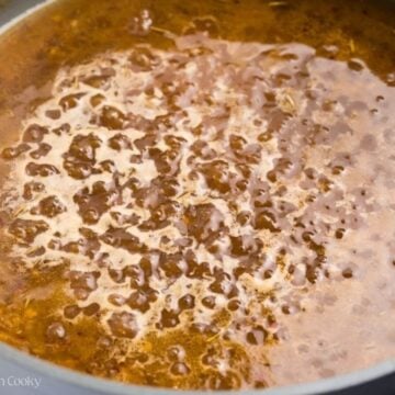Close up of a maple glaze simmering in a skillet.