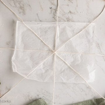 4 pieces of bakers twine on parchment sheet set in a spoke pattern.