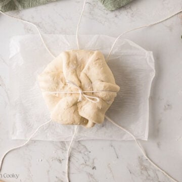 Brie on twine, with one string tied.