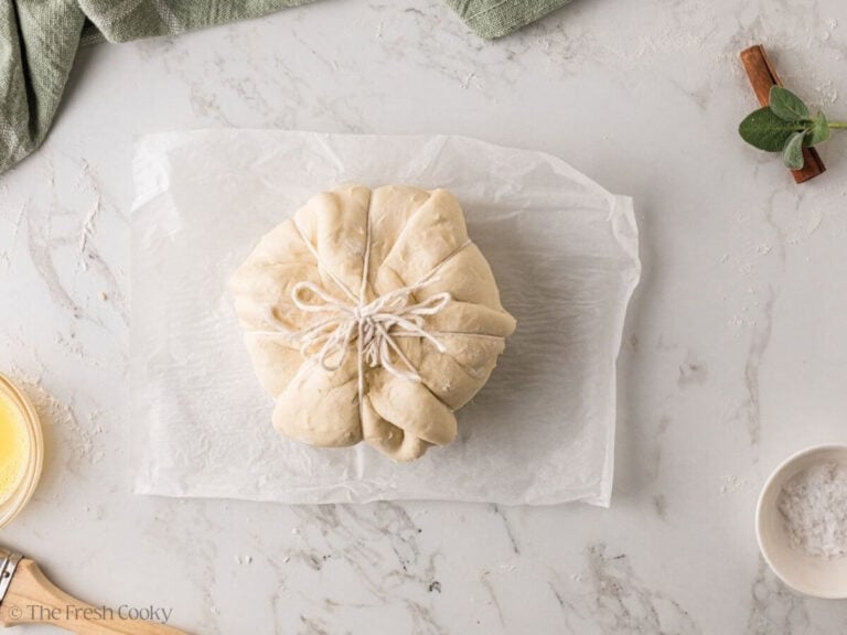 Kitchen twine tied over the seam of pastry-wrapped brie.