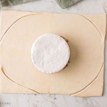 Corners trimmed on puff pastry around the brie.