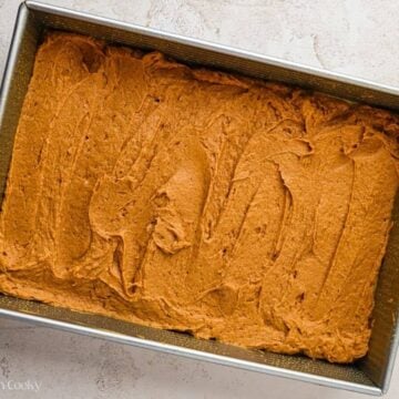 Pumpkin cake batter spread in the bottom of a baking dish.