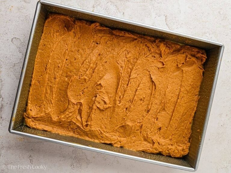 Pumpkin cake batter spread in the bottom of a baking dish.