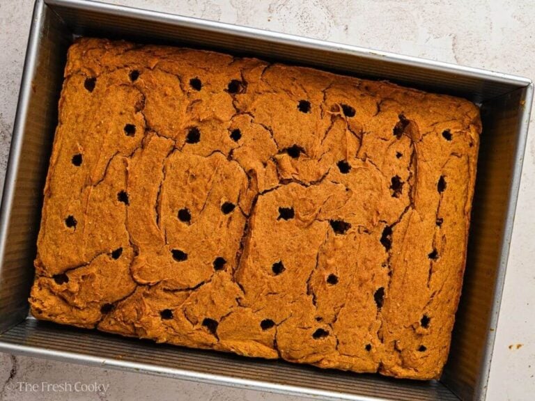 Holes poked into a baked pumpkin cake.